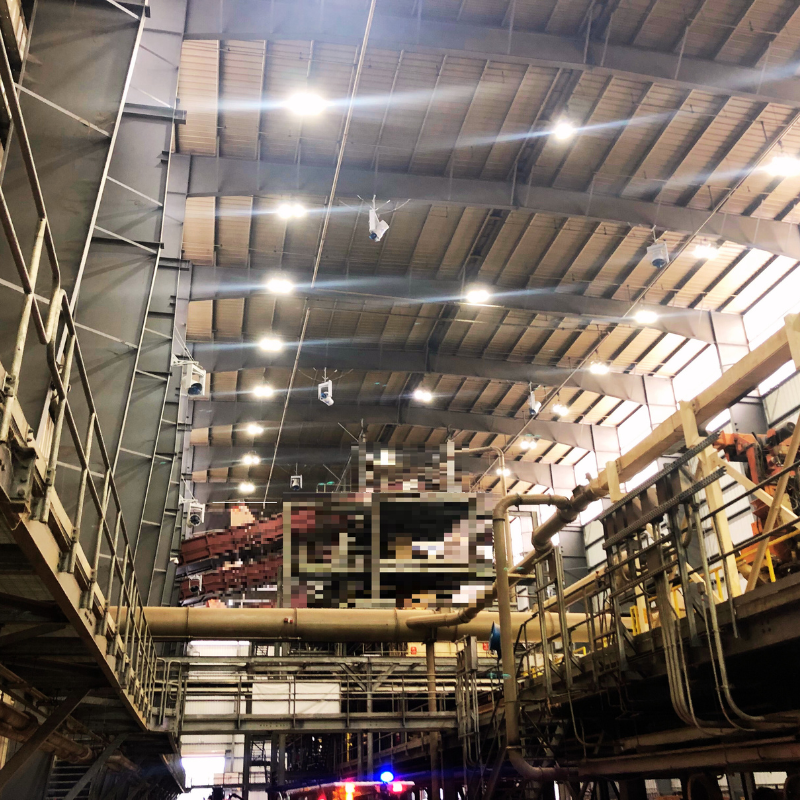  A group of high-powered industrial fan mounted on the ceiling, effectively controlling dust and debris in a warehouse setting.